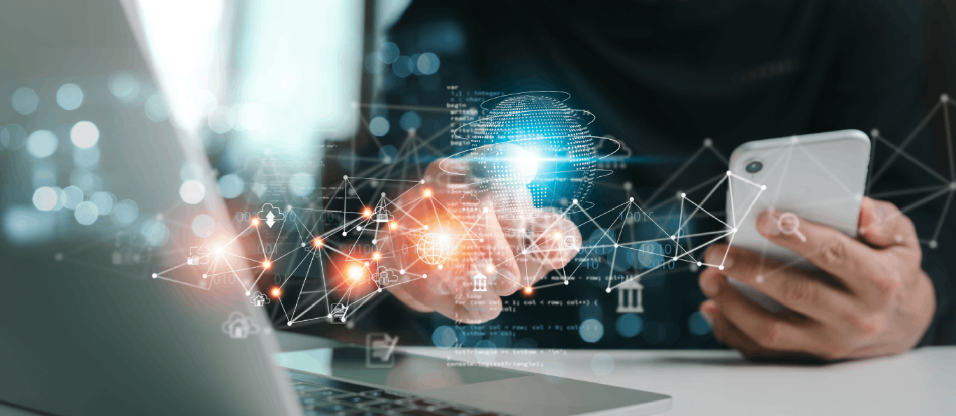 Person using a smartphone and laptop with holographic global network graphics symbolizing digital connectivity.